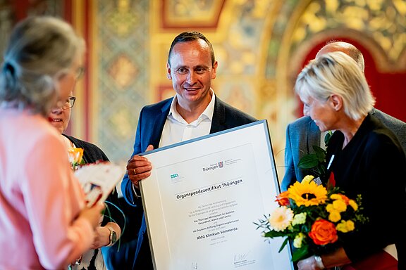 Vertreter des KMG Klinikums Sömmerda mit einer großen eingerahmten Urkunde